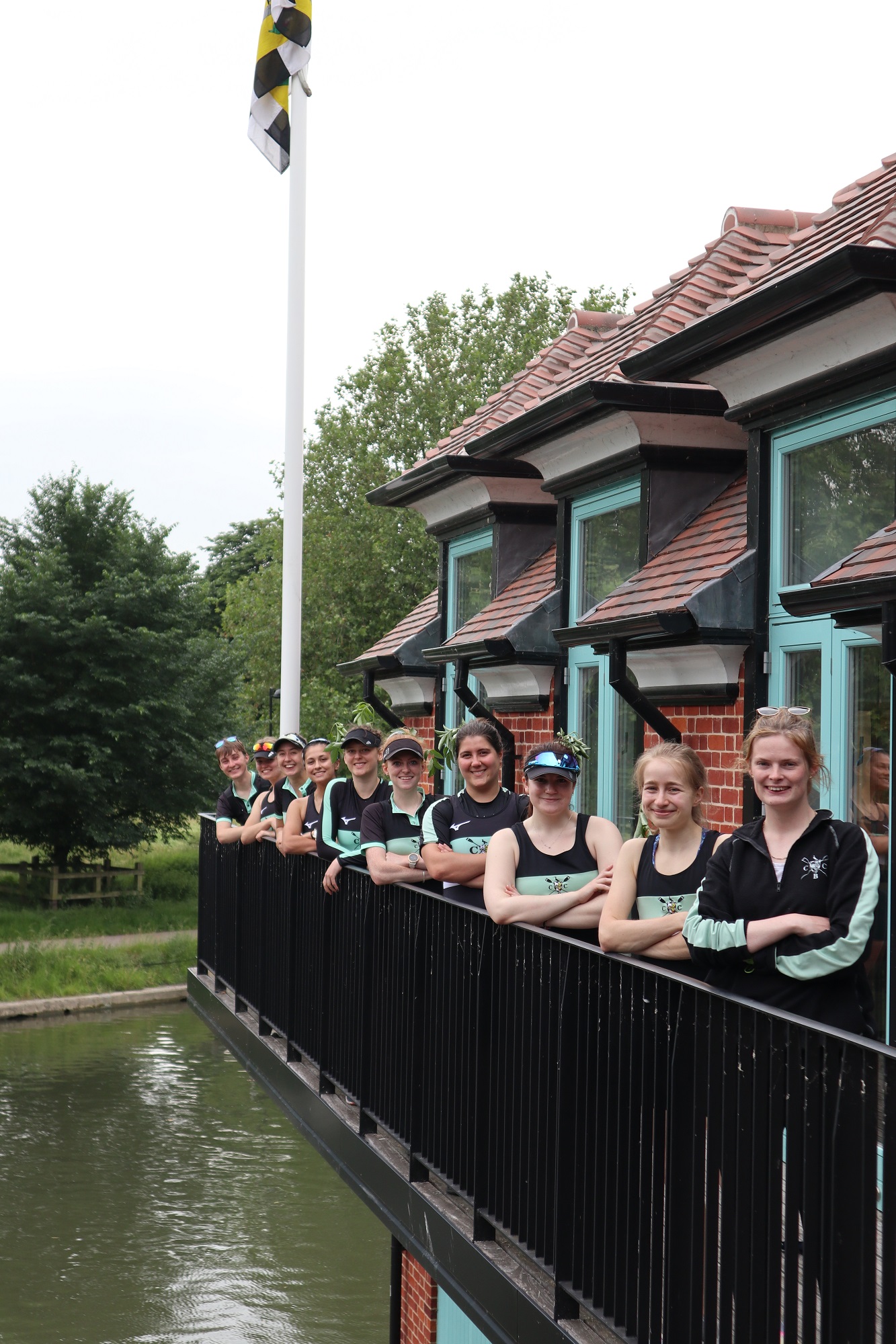 Caius women's 1 crew posing on the balcony at the Boat House
