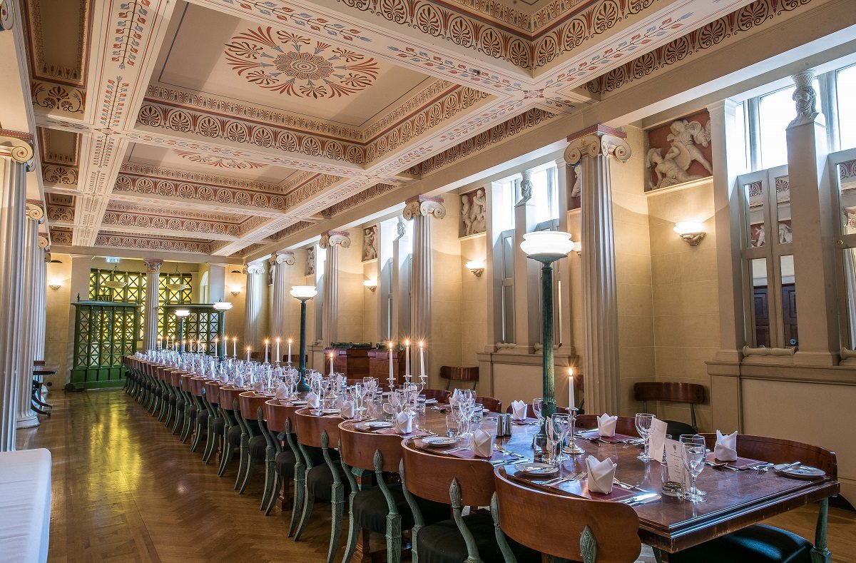 A long table set for dinner in a classically designed room