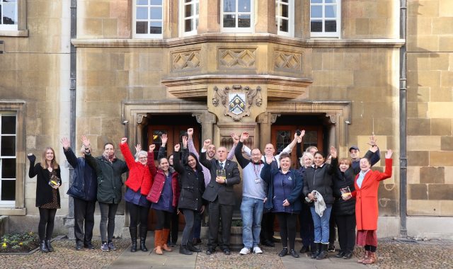 Staff celebrate three Cambridge BID awards with their hands in the air