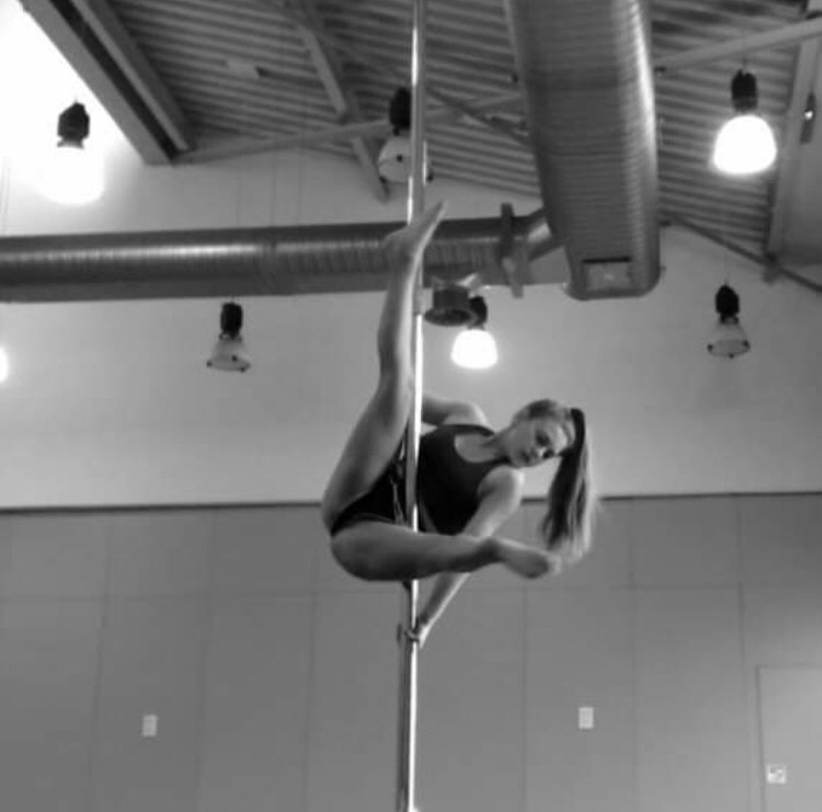 Eve Carcas performing acrobatics on a vertical pole