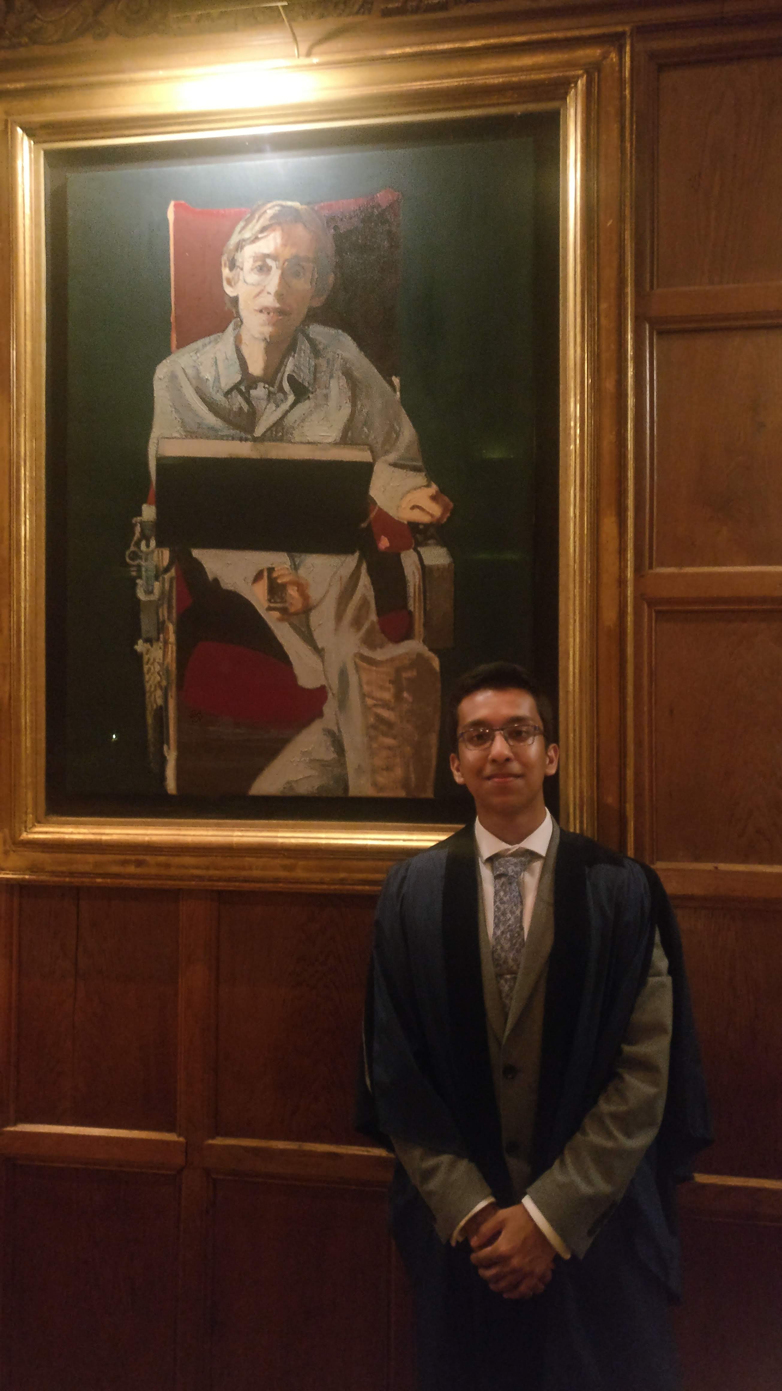 Azmaeen Zarif standing next to a portrait of Professor Stephen Hawking