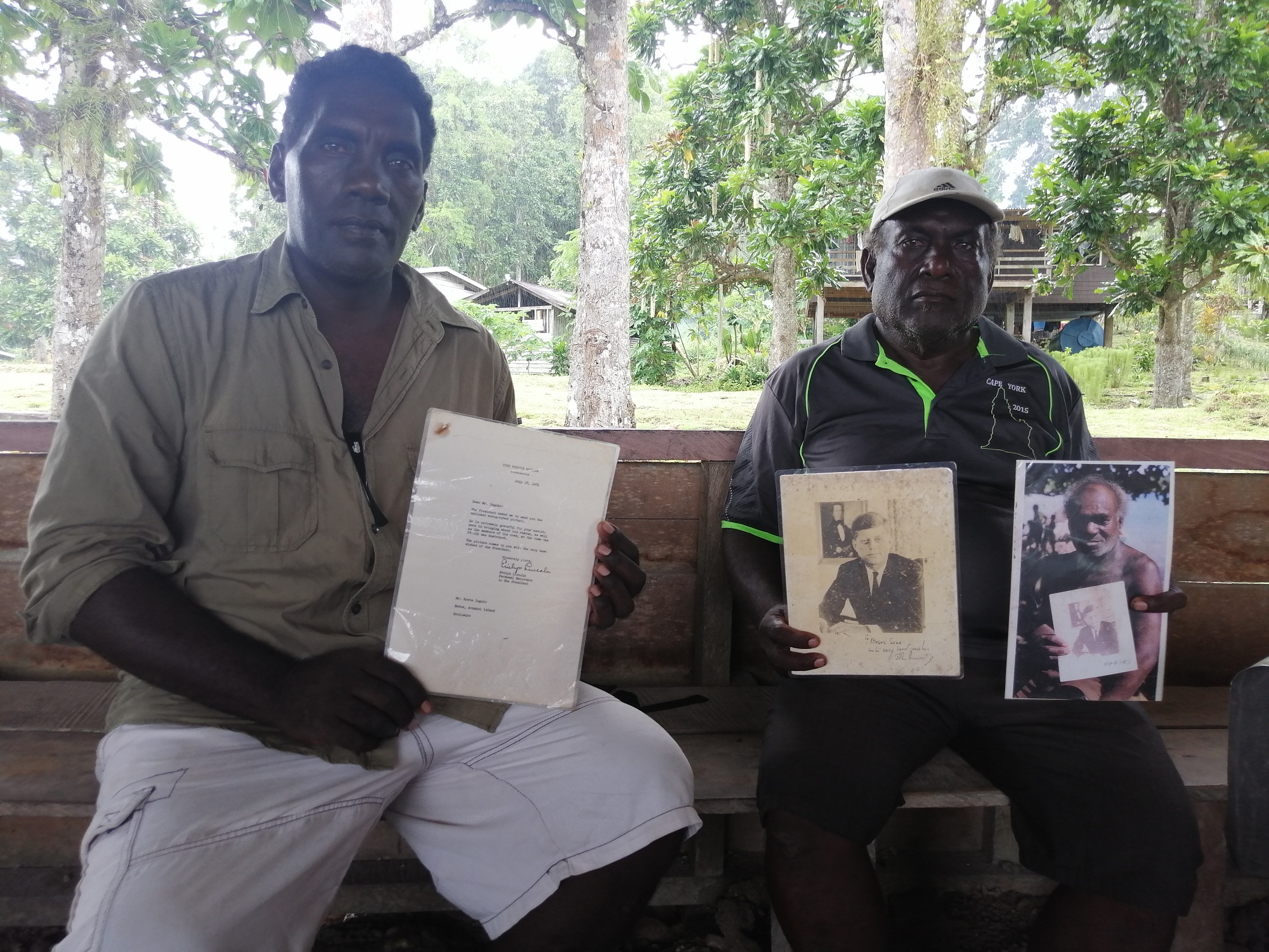 Two men showing a war time letter and photos on the Solomon Islands