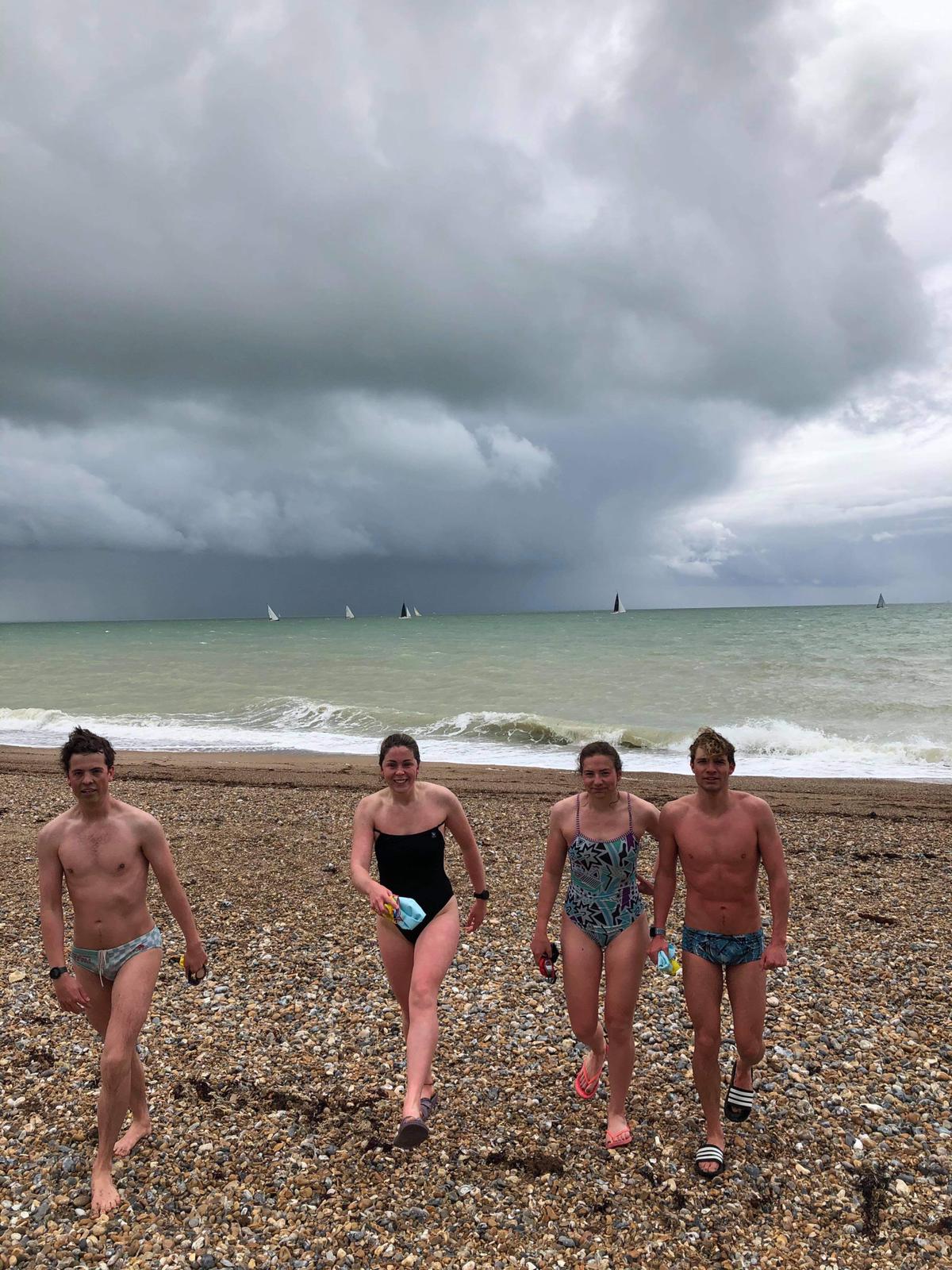 Four swimmers on Brighton beach following a training session