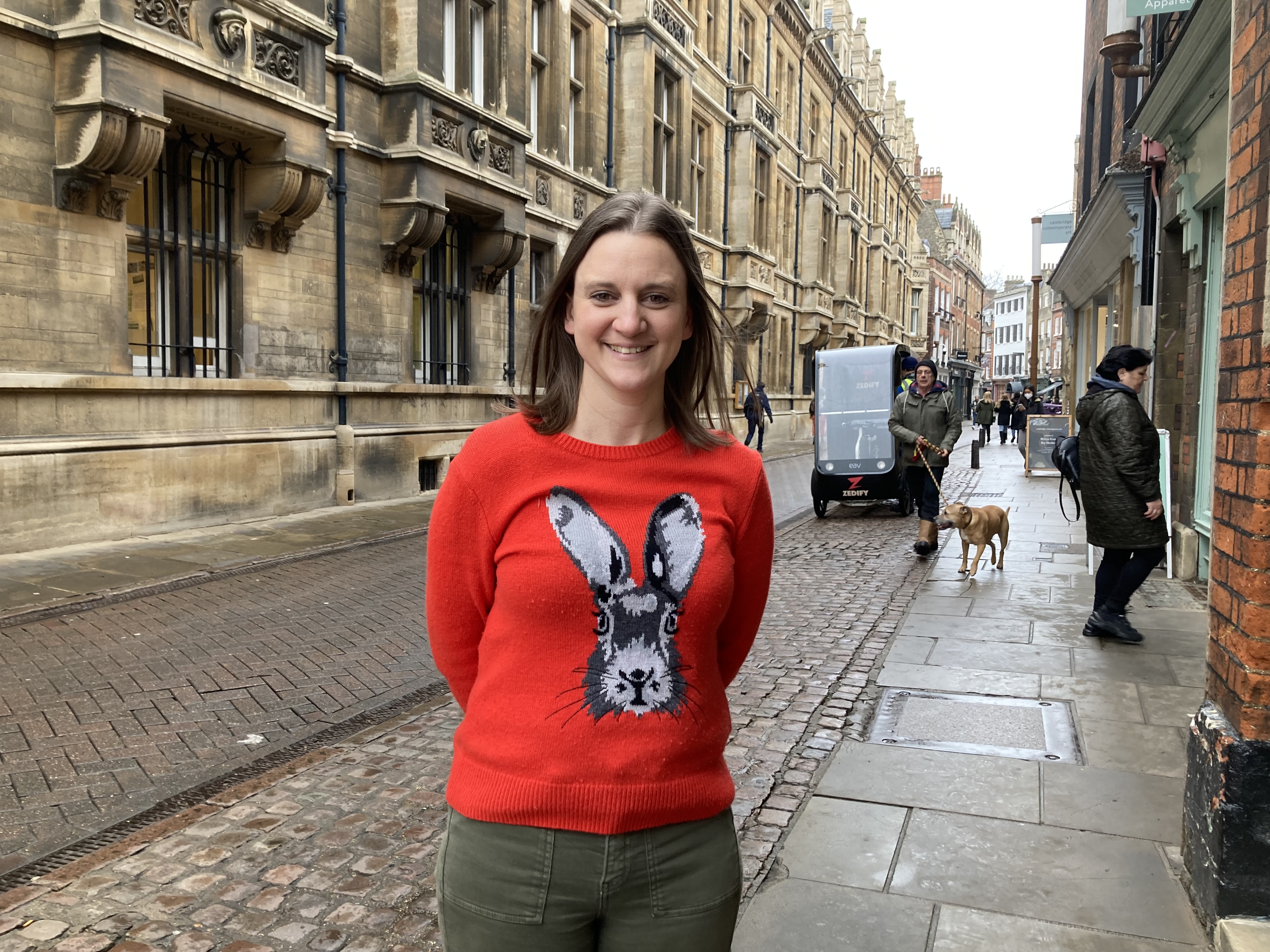 A woman wearing a red jumper with a rabbit's face on it
