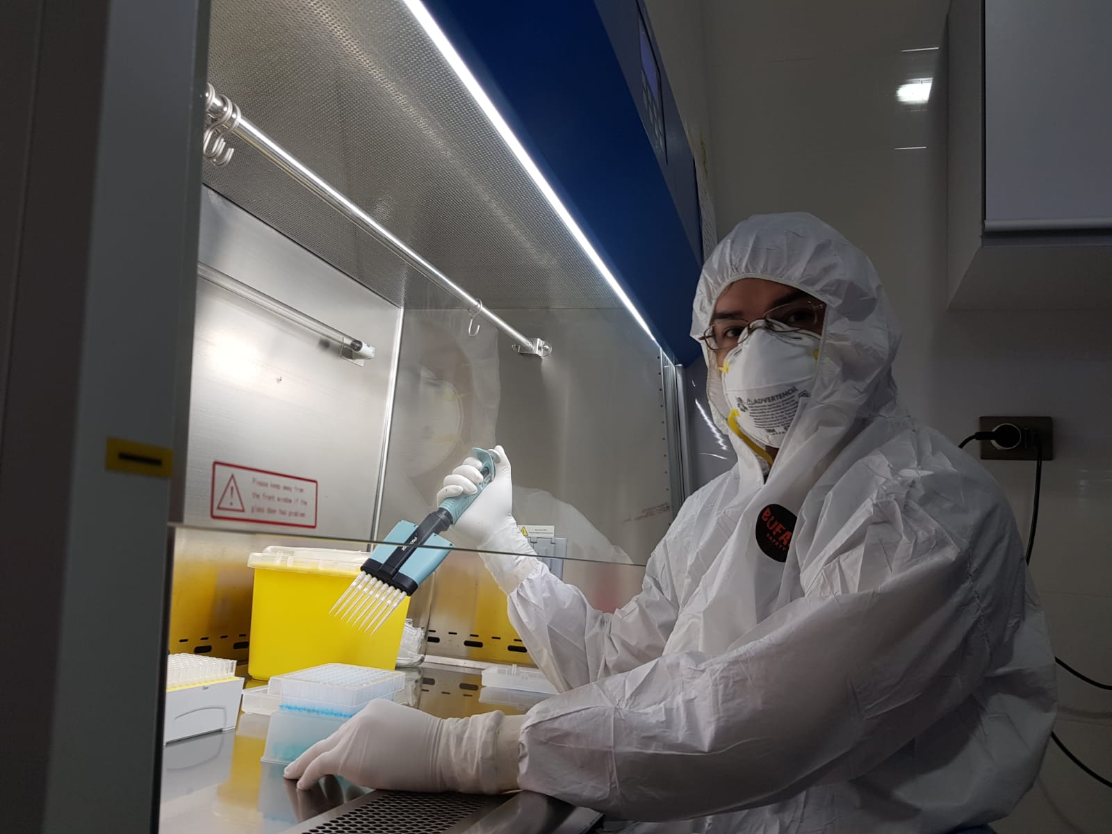 Eduardo Santander in full PPE testing Covid samples in a laboratory