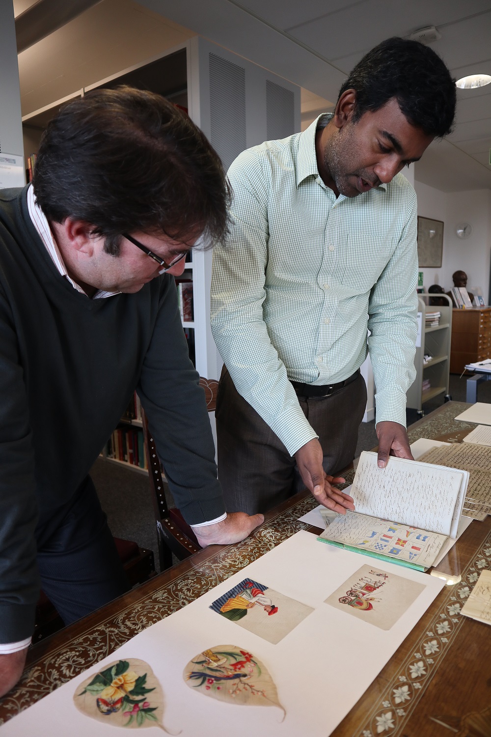 Centre of South Asian Studies: Archivist Kevin Greenbank (left) and Sujit Sivasundaram (right) looking at illustrated manuscripts