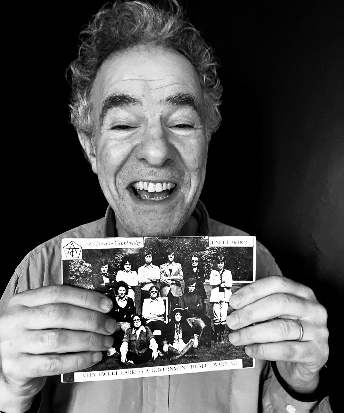 A man holding a photograph in a black and white photograph