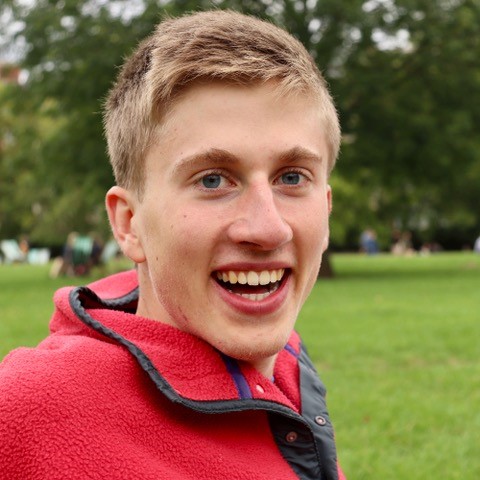 A man in a red jumper smiling