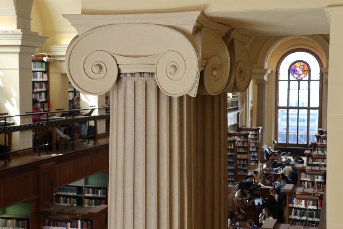 The top of a column with a library behind