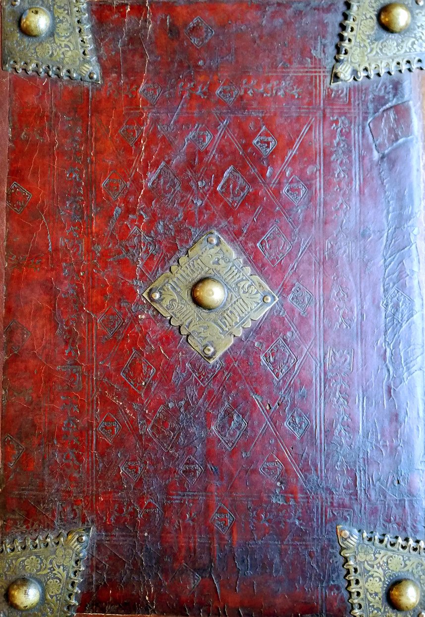 One of the Manual's calfskin-bound boards, with a stamped diaper pattern (repeating diamonds) and five brass bosses at the corners and in the centre.