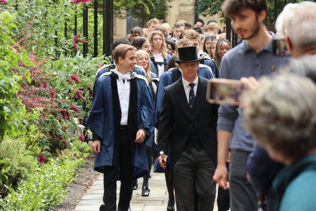 A graduation procession led by the Head Porter in a top hat