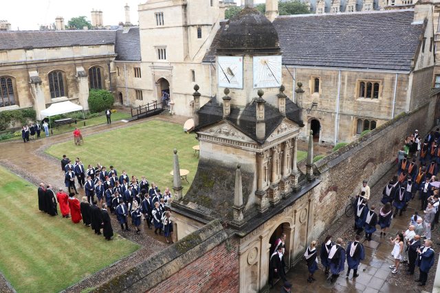 A graduation procession through the Gate of Honour at Caius College