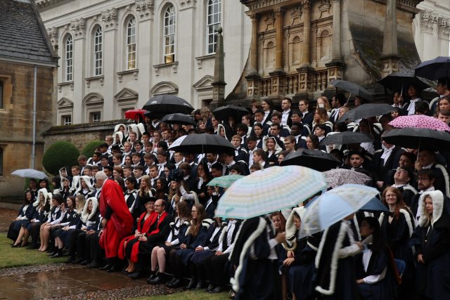 A graduation photo featuring umbrellas due to rain