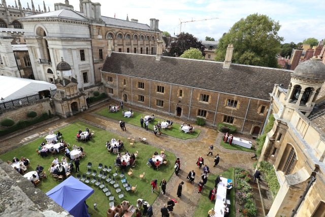 An aerial view of a lawn with tables and chairs and lots of people